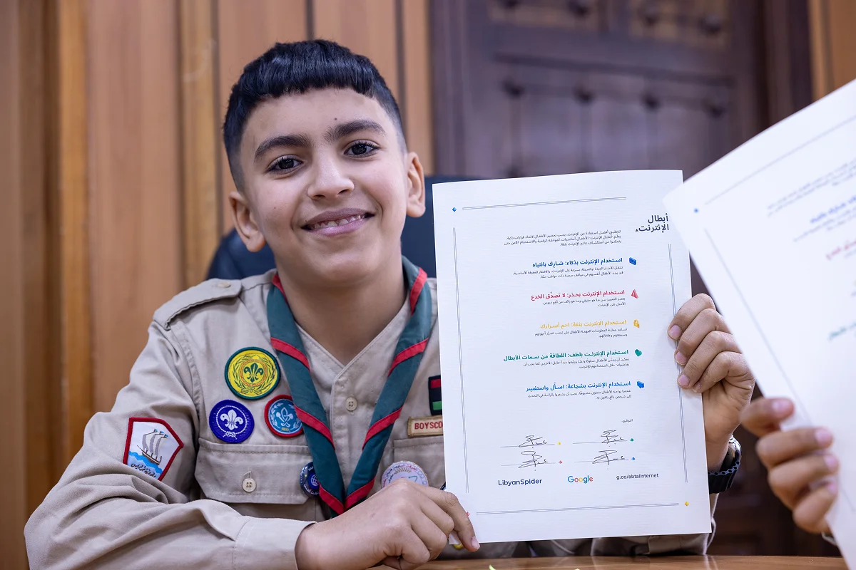 A young participant holding a certificate at an LS Gives digital safety activity